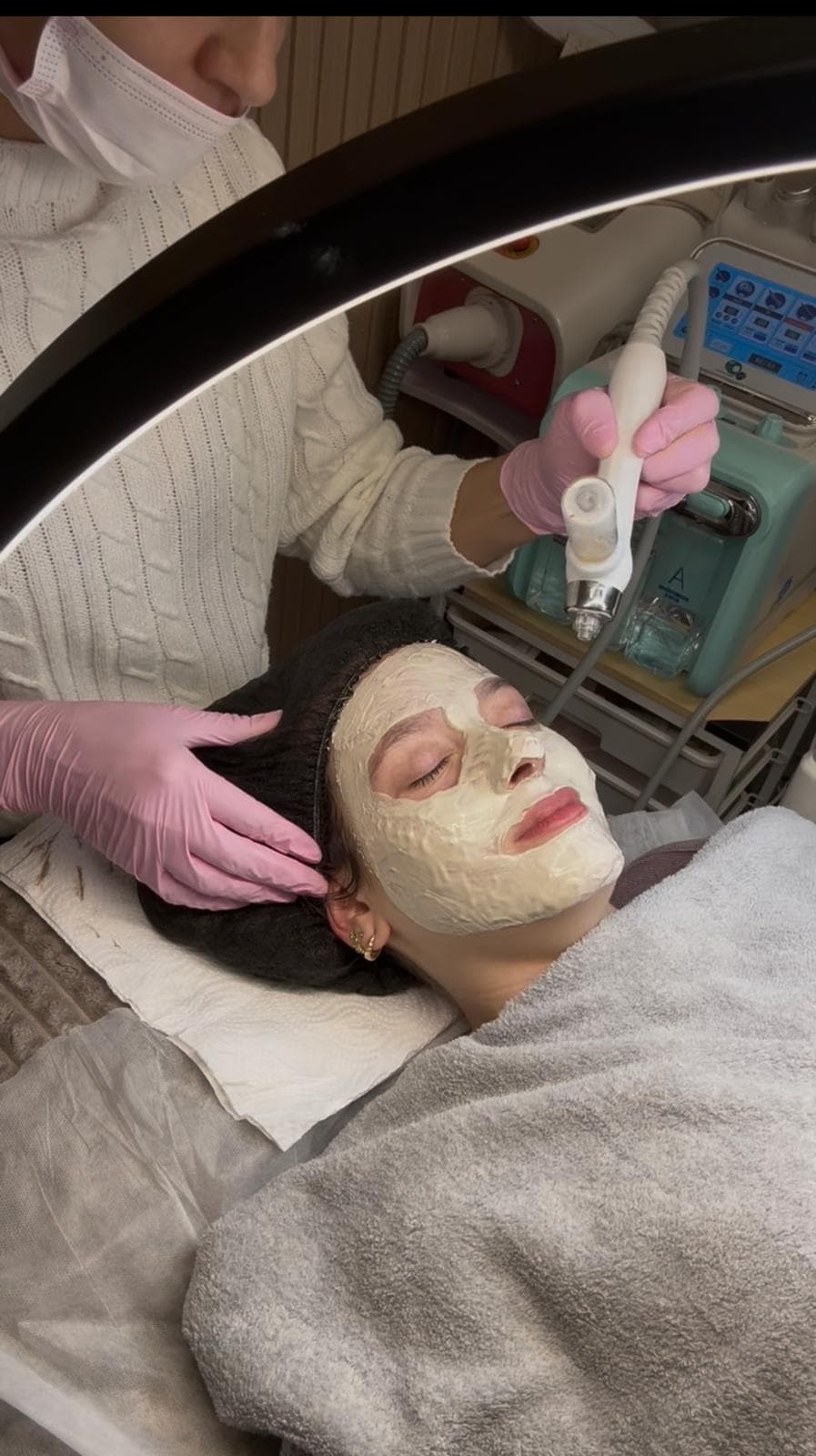 A client rests with a cream mask on her face during a facial.