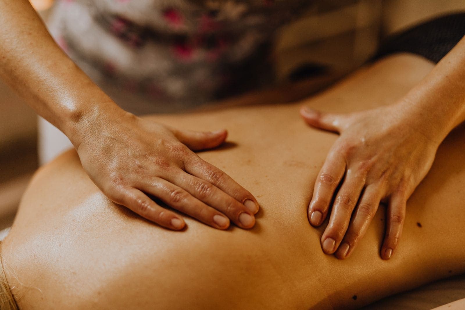 Hands giving a back massage.